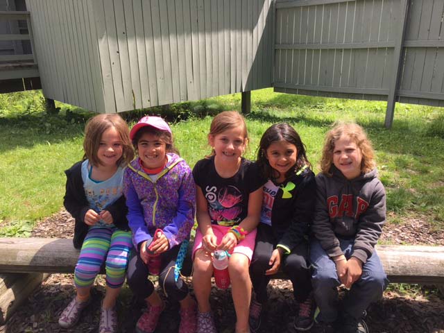 Summer camp girls sitting on a bench